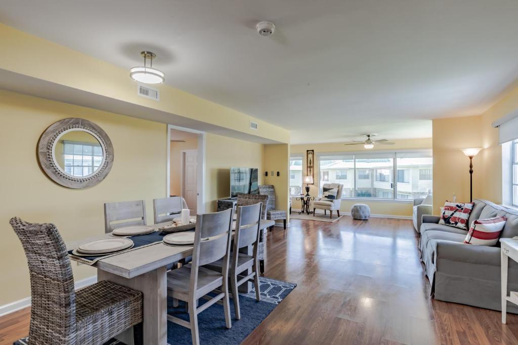 a dining room and living room with a table and chairs at Stylish Condo with a view of the water in Dauphin Island