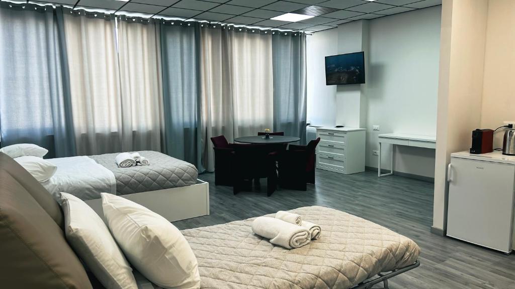 Cette chambre comprend 2 lits et une table. dans l'établissement Loft Office 1, à Castel Maggiore