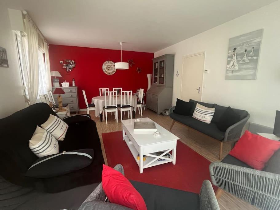 een woonkamer met 2 banken en een rode muur bij Havre de paix en plein centre du touquet in Le Touquet-Paris-Plage