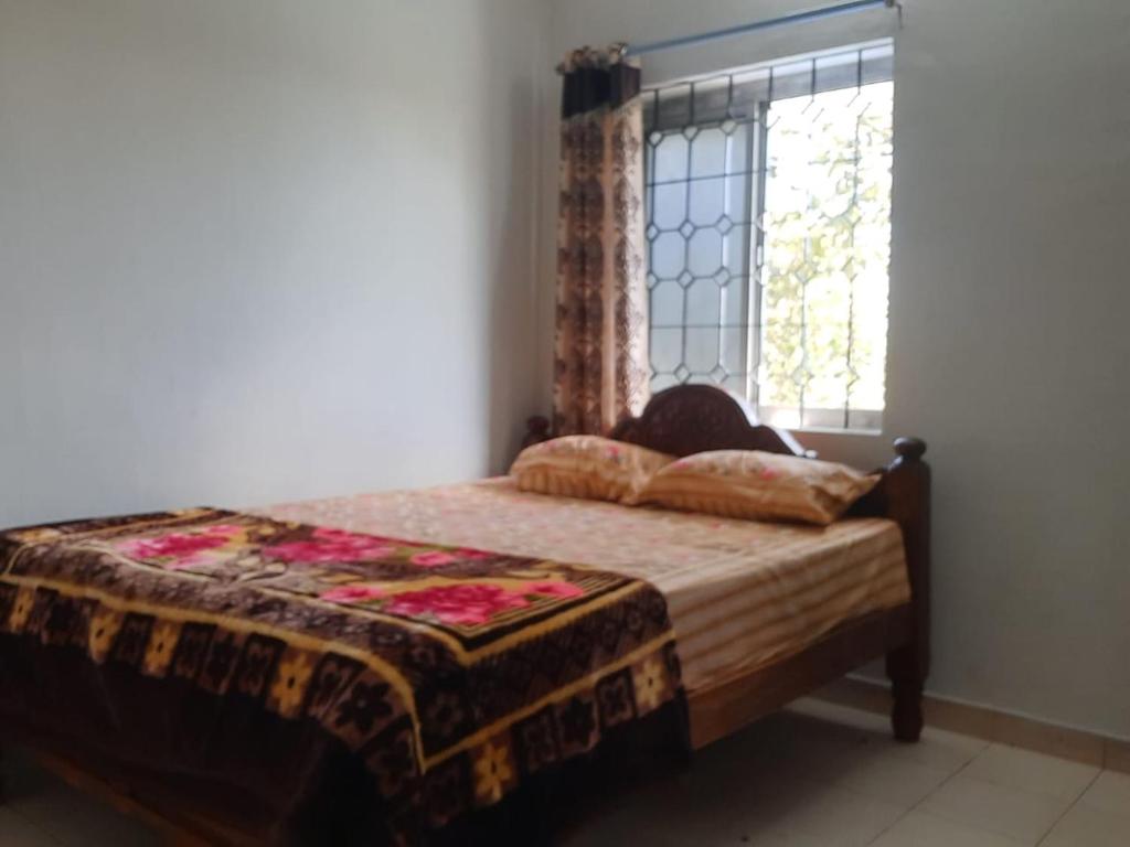 een slaapkamer met een bed met een raam en een deken bij Royal King Room's in Yercaud