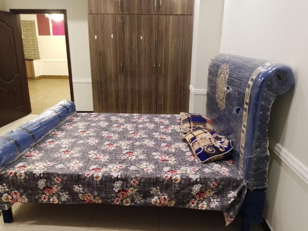 Una cama con edredón en una habitación en Rayan hight, en Islamabad