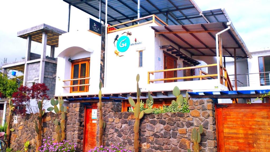 uma casa com uma parede de pedra em frente em Hostal GalaHouse em Puerto Ayora