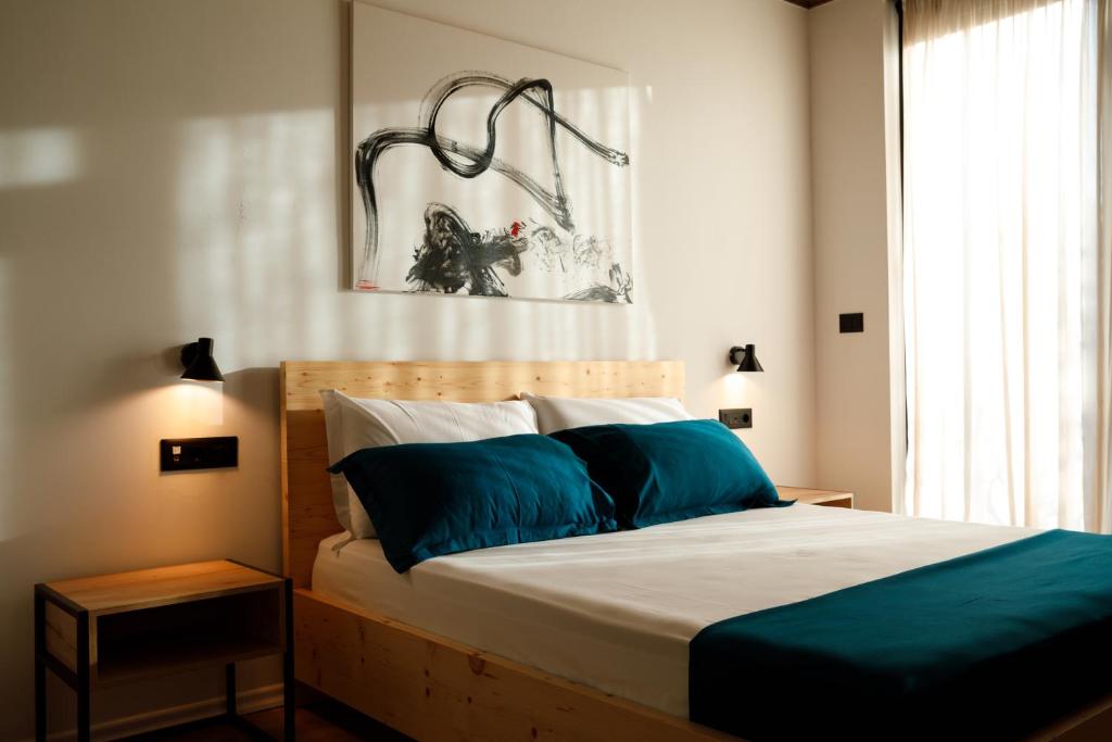 a bedroom with a large bed with blue pillows at The Barrels Ms in Gjirokastër
