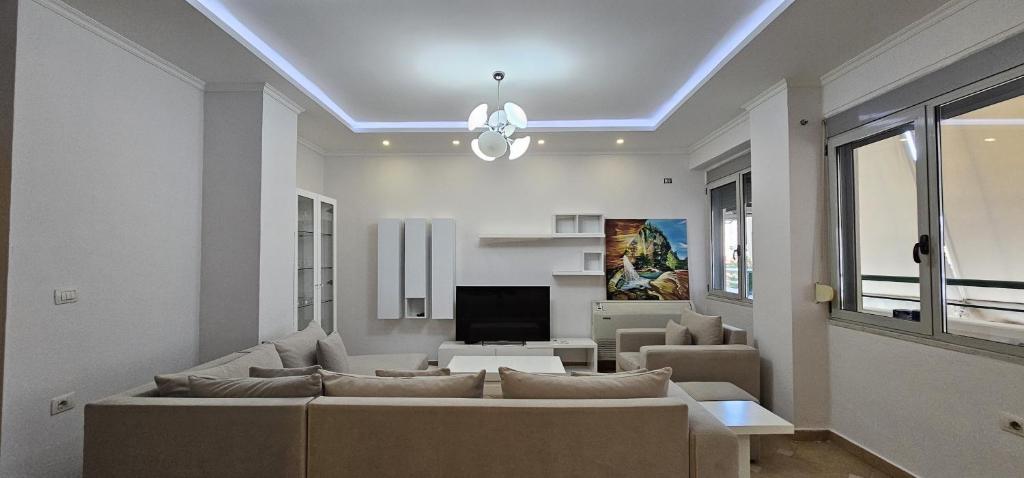 ein Wohnzimmer mit einem Sofa und einem TV in der Unterkunft TAM 2BDR Centre Apartment With Veranda in Tirana