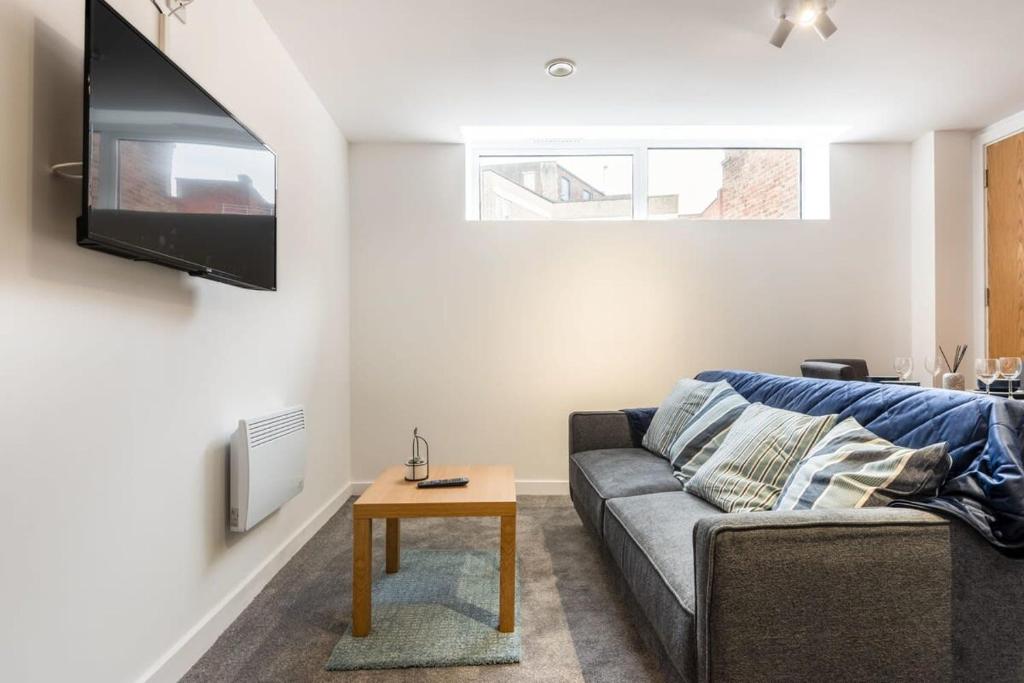a living room with a couch and a tv at Cosy 1 Bedroom Apartment in Central Sheffield in Sheffield