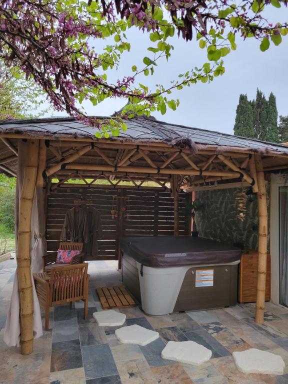 Au secret des Brégines في بيزييه: شرفة خشبية مع حوض استحمام ساخن ومقعد