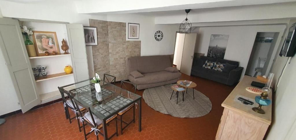 uma sala de estar com um sofá e uma mesa de vidro em Charmant appartement en centre-ville 70m2 em Digne-Les-Bains