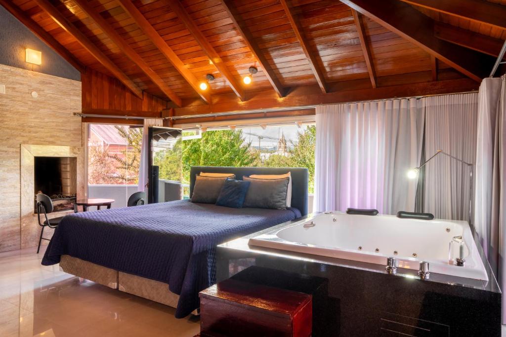 FIKA Residence في دويس إيرماوس: غرفة نوم بسرير وحوض استحمام بجانب سرير وحوض استحمام