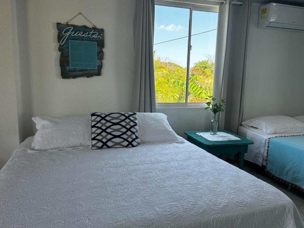 ein Schlafzimmer mit einem weißen Bett und einem Fenster in der Unterkunft Miss Francia´s Home in Santa Catalina Island