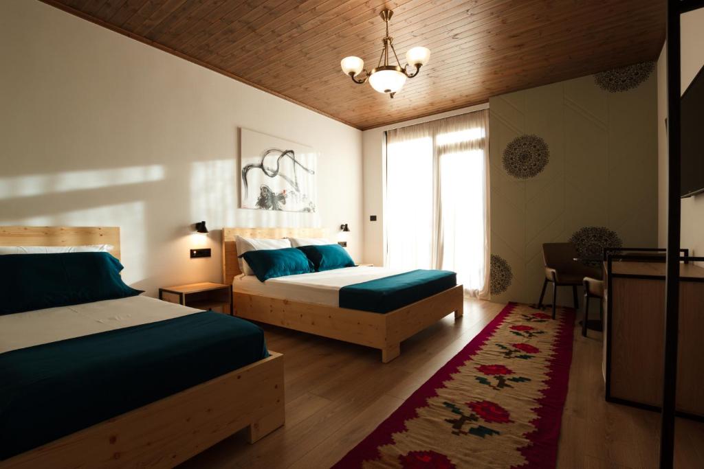 a bedroom with two beds and a chandelier at The Barrels Ms in Gjirokastër