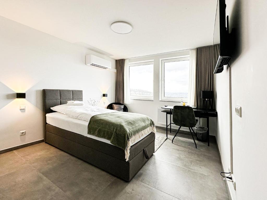 a bedroom with a bed and a desk in it at SI-View Einzelzimmer mit Stadtblick Zimmer 19 - Hotel in Siegen