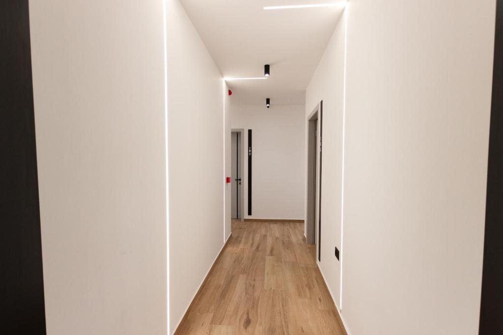 an empty hallway with white walls and wood floors at The Barrels Ms in Gjirokastër
