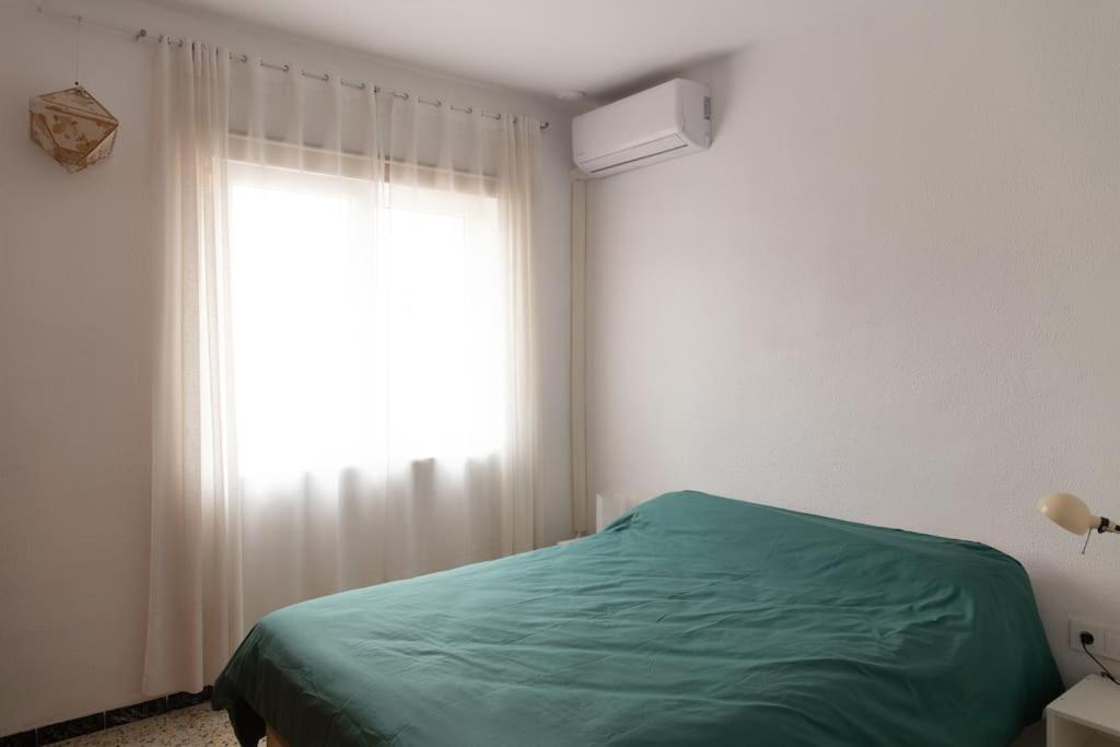 a bedroom with a green bed and a window at Hogar del Sur by Gades Gestión in Cádiz