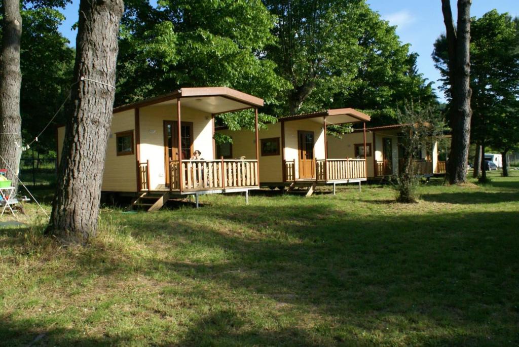 a small house with a porch and a tree at CAMPING AMALASUNTA in Montefiascone