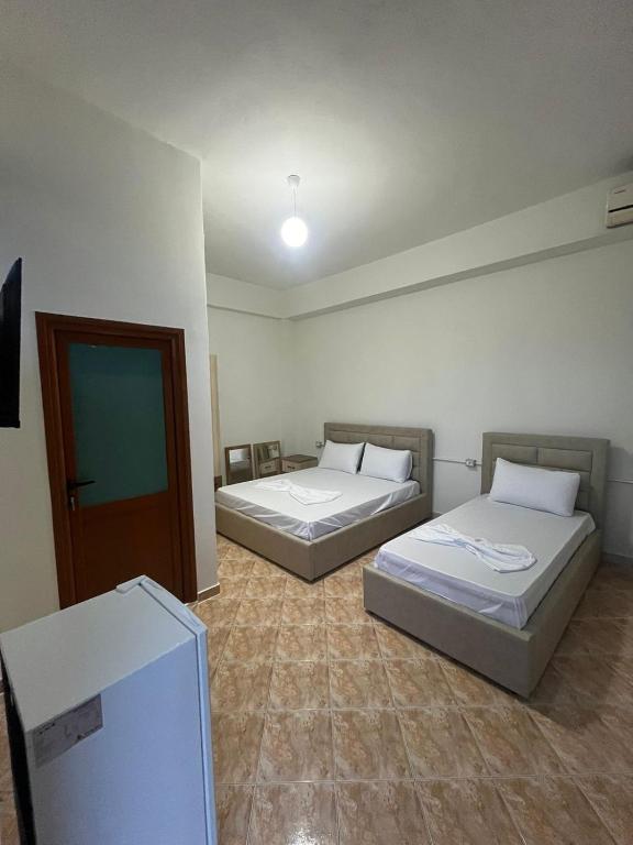 een kamer met 2 bedden en een tv. bij Guest_House_Toska in Berat