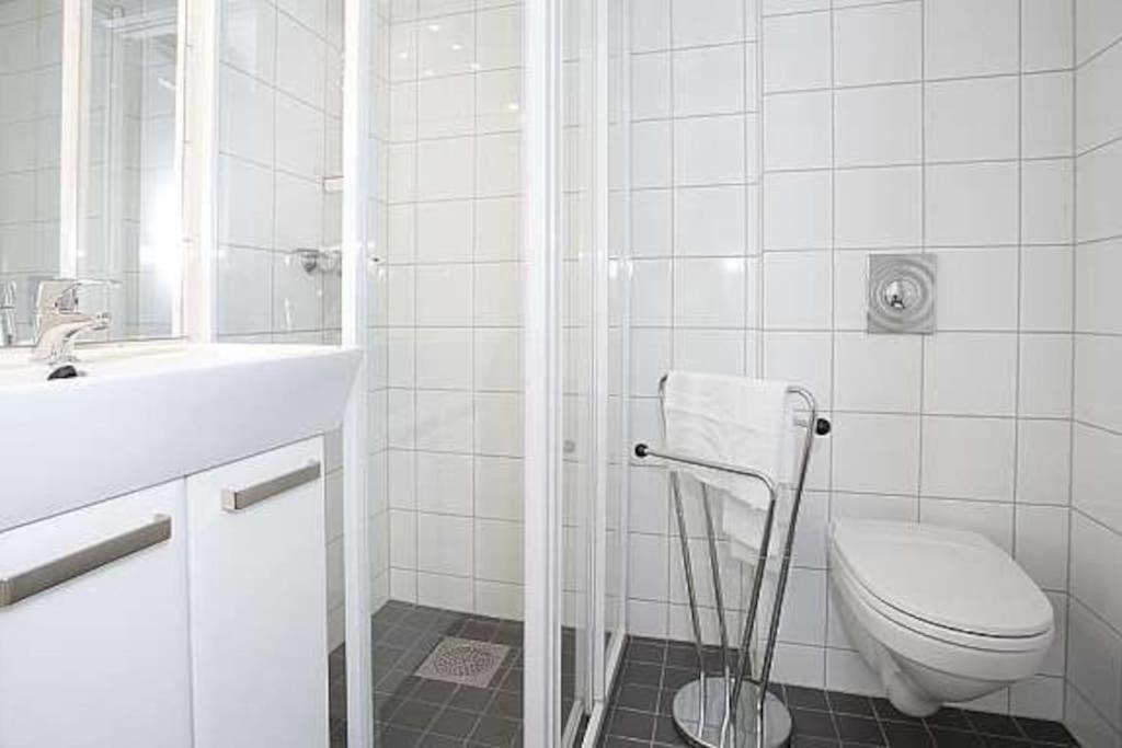 La salle de bains blanche est pourvue de toilettes et d'un lavabo. dans l'établissement Leilighet i hjertet av kristiansand sentrum!, à Kristiansand