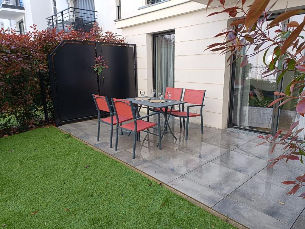 eine Terrasse mit einem Tisch und Stühlen auf einer Terrasse in der Unterkunft DISNEY - PARIS 5 Min DE DISNEY - PK privé gratuit - 4 personnes - Terrasse jardin in Chessy