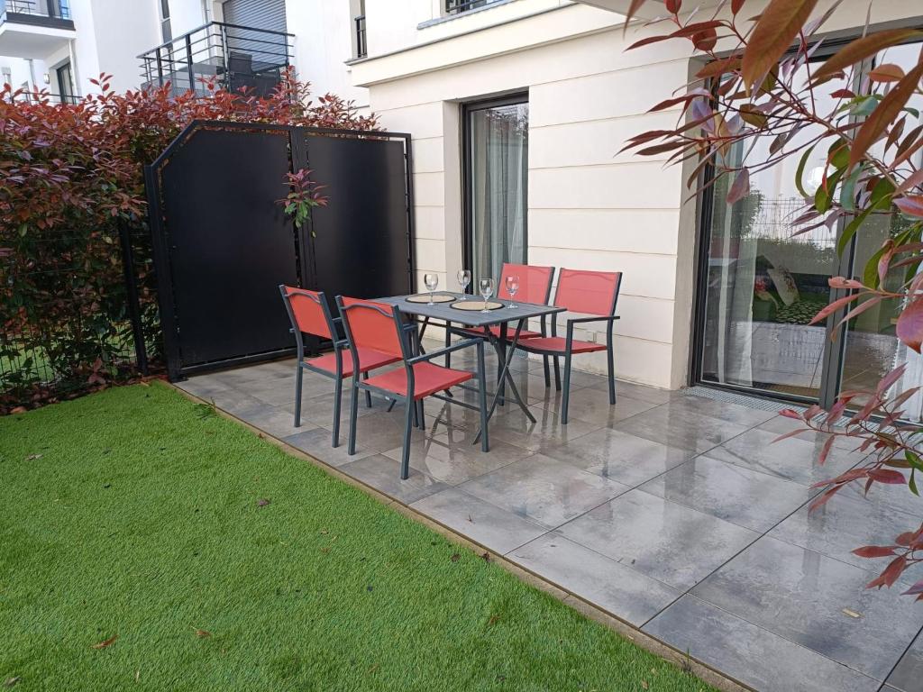 un patio avec une table et des chaises sur un patio dans l'établissement DISNEY - PARIS 5 Min DE DISNEY - PK privé gratuit - 4 personnes - Terrasse jardin, à Chessy
