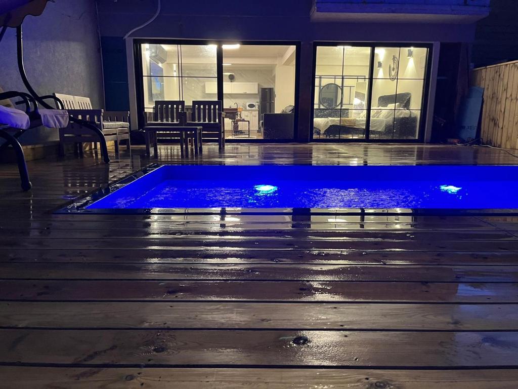una piscina con luces azules en una planta en מבית תכלת בית של חופש Allentown 21 אלנטאון 21, en Tiberíades
