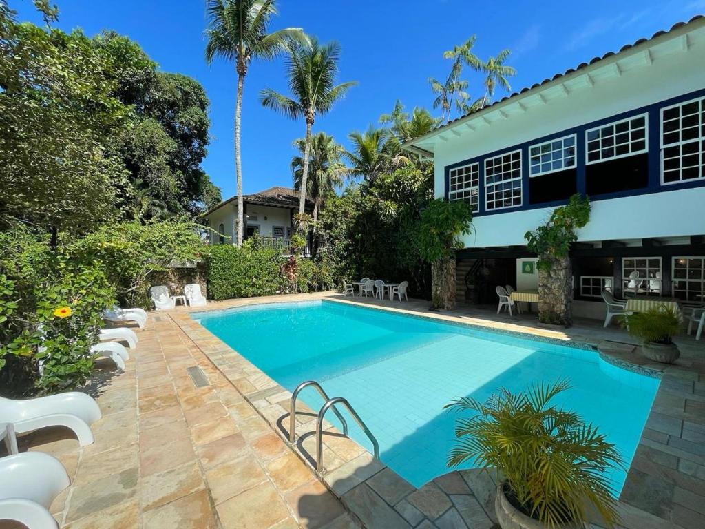 a swimming pool in front of a house at Hotel Solar das Águas Cantantes in Ubatuba