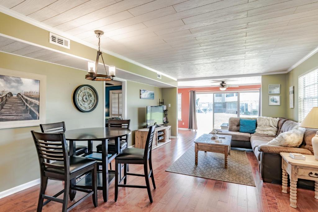 a dining room and living room with a table and chairs at East End Beach Side Bungalow in Dauphin Island