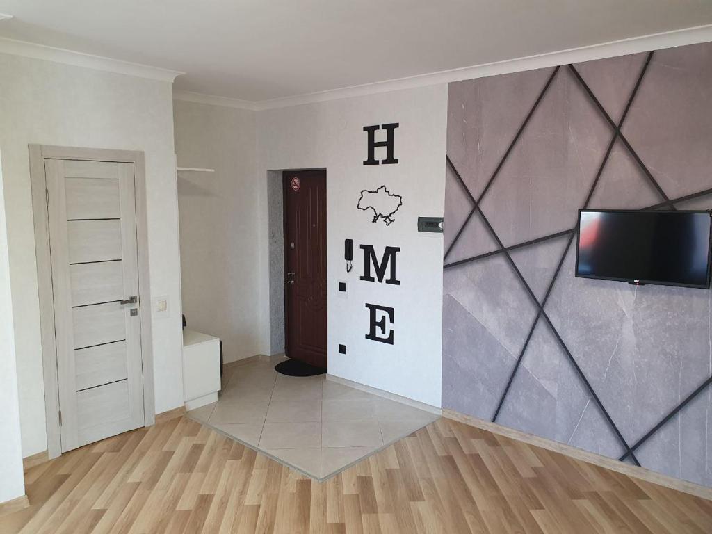 - un salon avec une télévision et un mur dans l'établissement Apartment na Shashkevicha 16, à Trouskavets