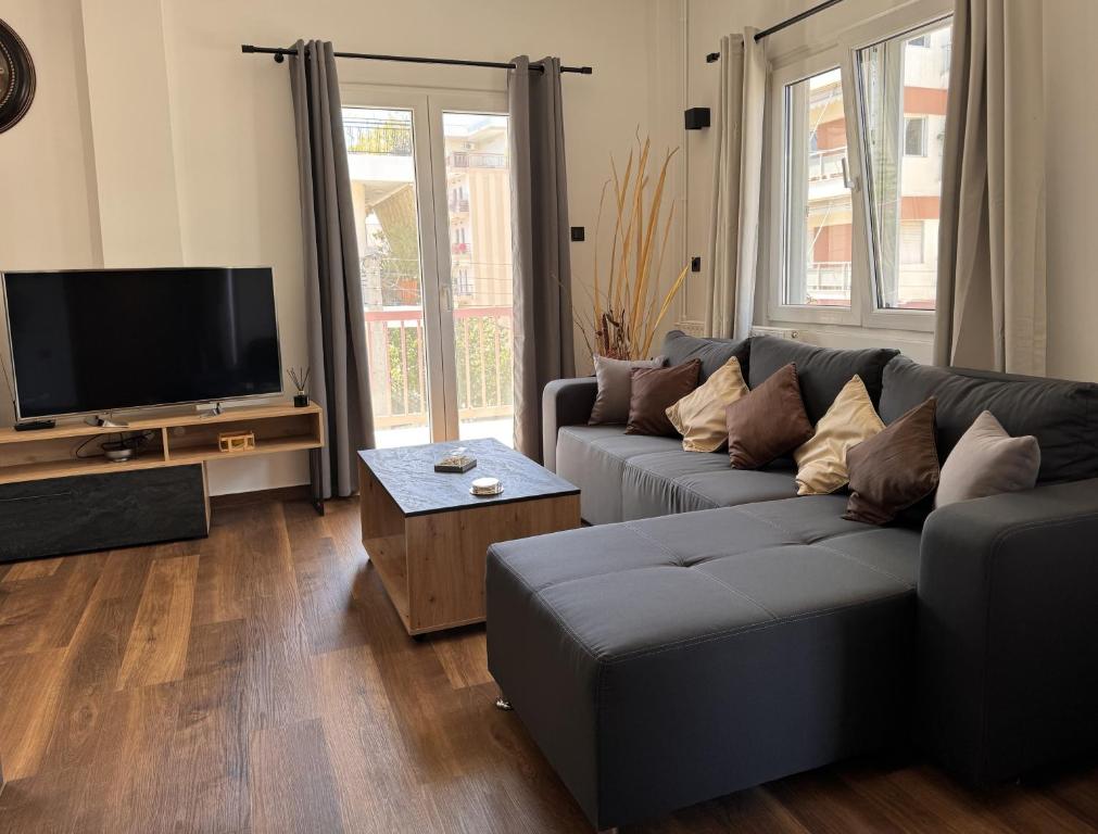 sala de estar con sofá y TV de pantalla plana en Navaro Apartments, en Patra