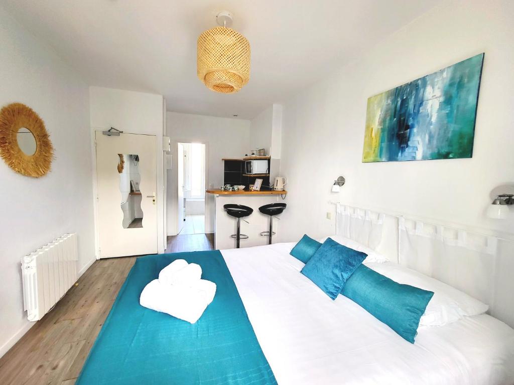 a bedroom with a white bed with a cloud on it at Swann - A 2 pas de la plage ! in Saint Malo