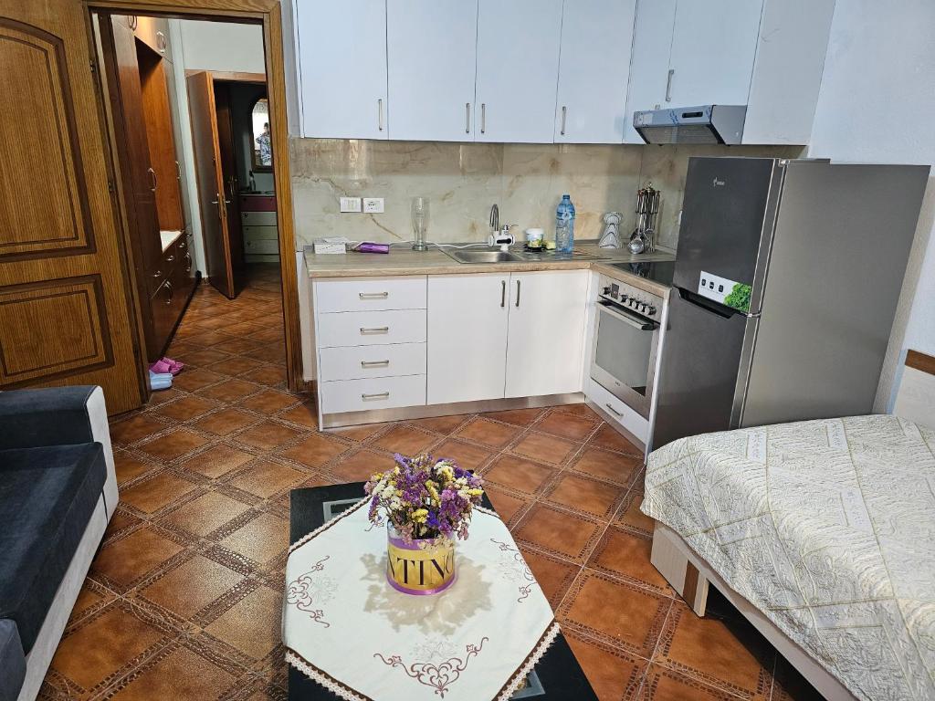 地拉那的住宿－Xhemi APARTAMENT，小厨房配有带鲜花的桌子