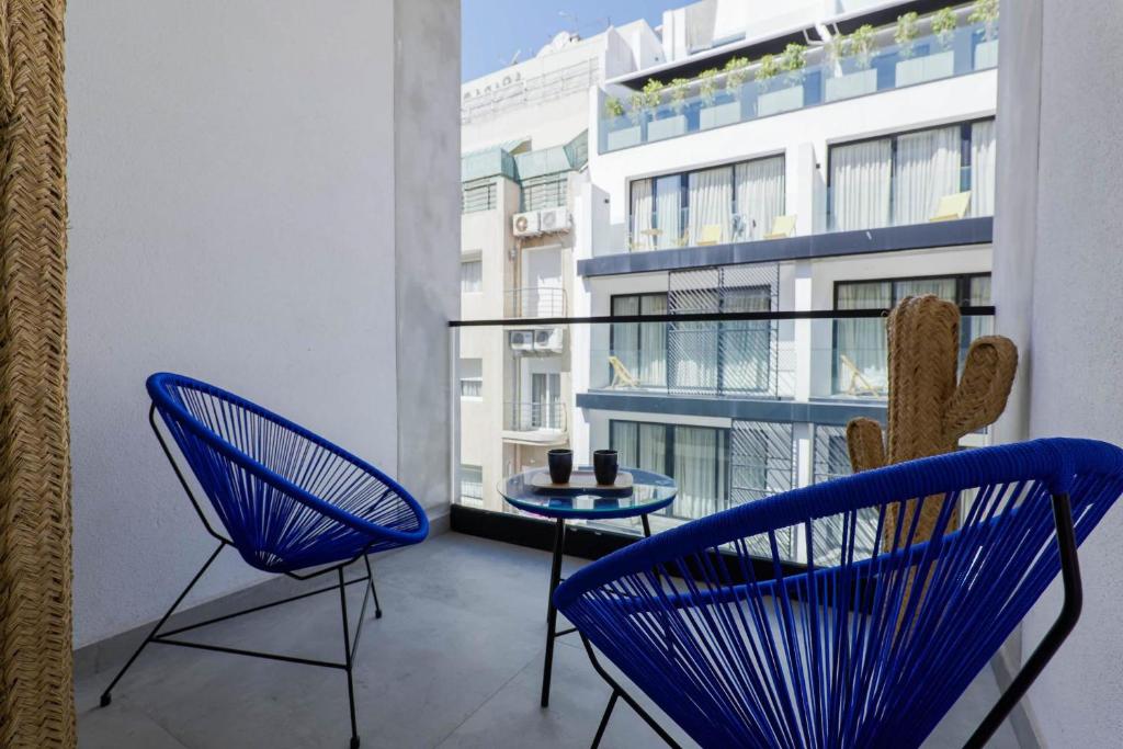 a balcony with blue chairs and a table and a cactus at So7 Gauthier furnished flat in Casablanca