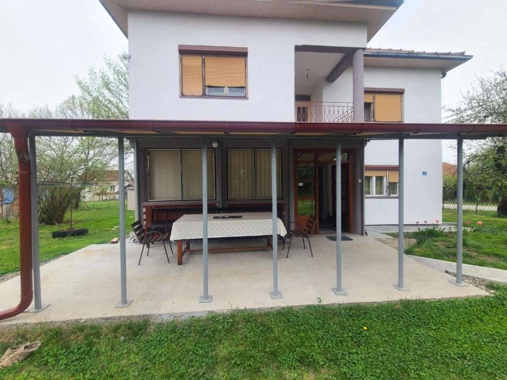 une maison avec une terrasse couverte en face de celle-ci dans l'établissement Nada, à Vrnjačka Banja