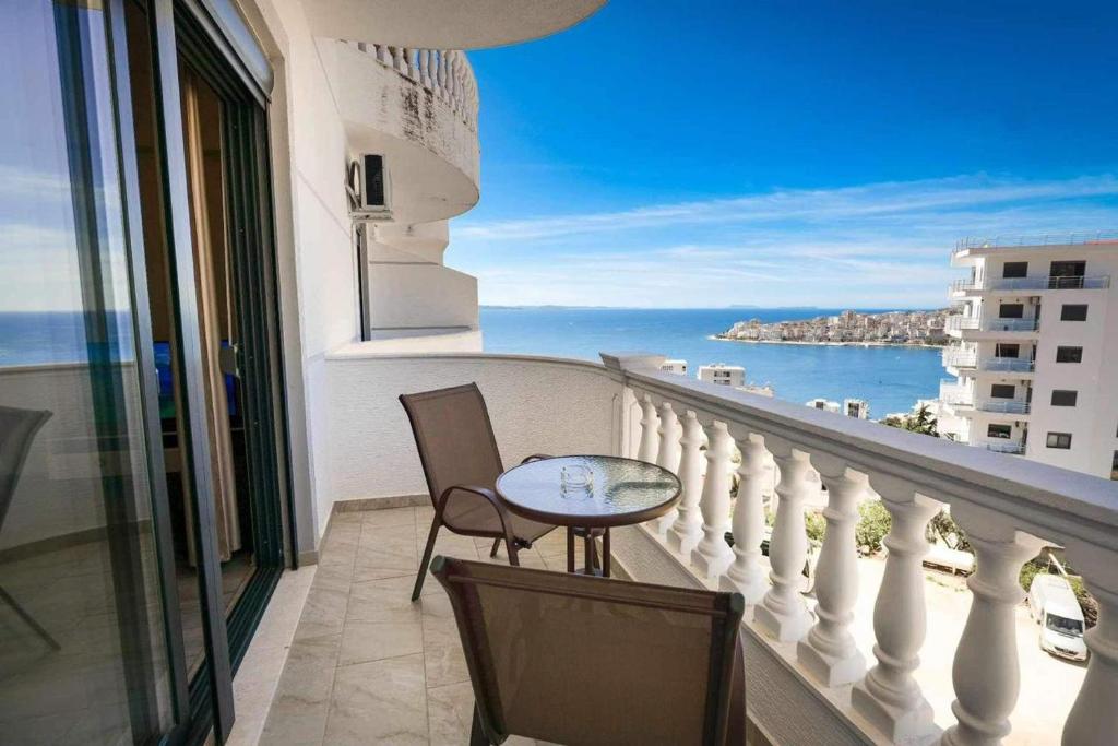 a balcony with a table and chairs and the ocean at Ari's Apartment Sarande in Sarandë