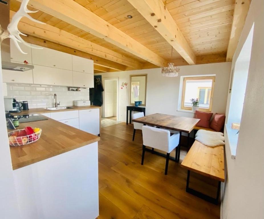 a kitchen and living room with a wooden ceiling at Urlaub im Grünen - Charmantes Bauernhaus in Bad Waltersdorf