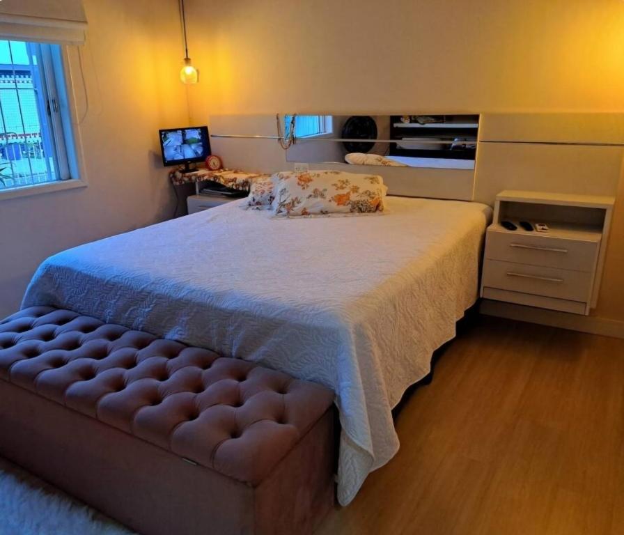 a bedroom with a large bed and a couch at Excelente Quarto prox centro Criciuma in Criciúma