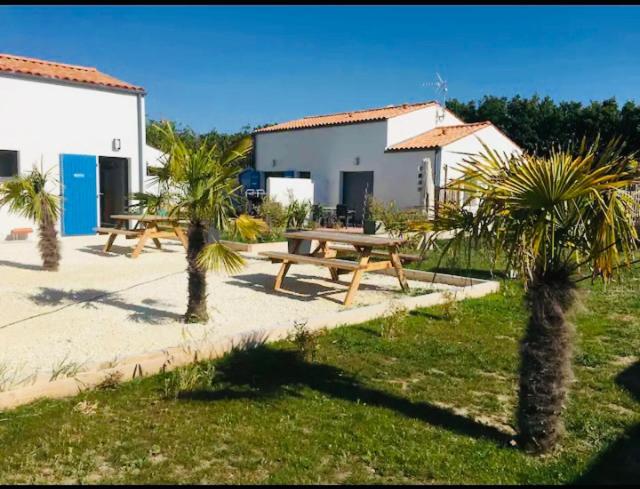 deux tables de pique-nique et des palmiers devant un bâtiment dans l'établissement marine, à Foulerot
