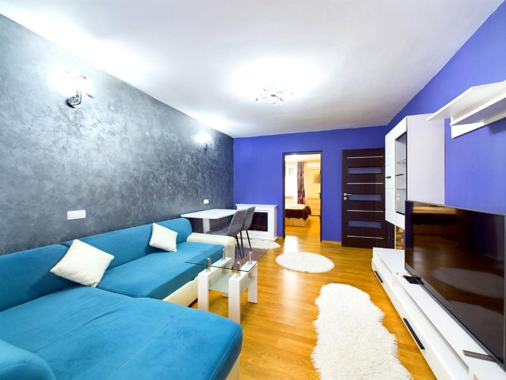 a living room with blue walls and a blue couch at Toni’s place in Braşov