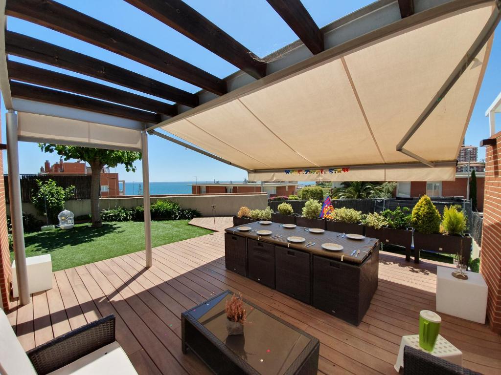 un patio con una sombrilla grande en una terraza en Villa Beach Barcelona, en Montgat