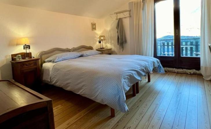 a bedroom with a bed and a large window at Lo noú in Aosta