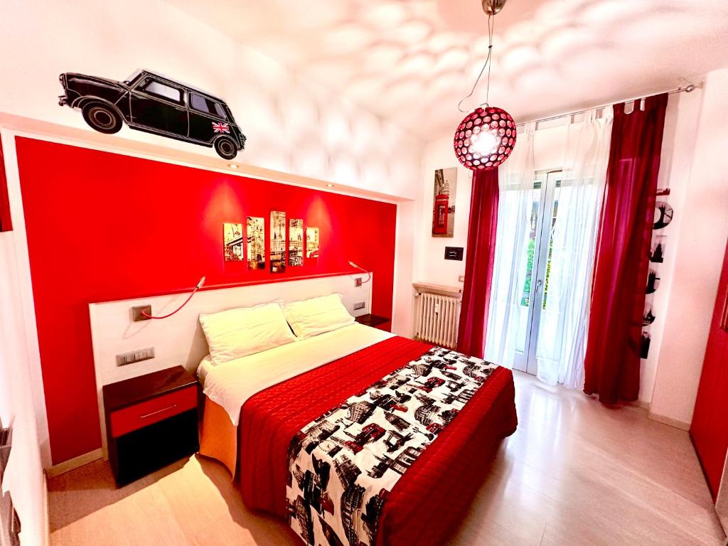 een rode slaapkamer met een bed met een auto aan de muur bij Ai Giardini Rooms in Verona