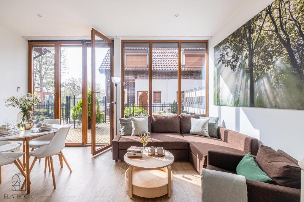 a living room with a couch and a table at Flatbook Apartamenty - Mikoszewo Dom Amber Cottage in Nickelswalde