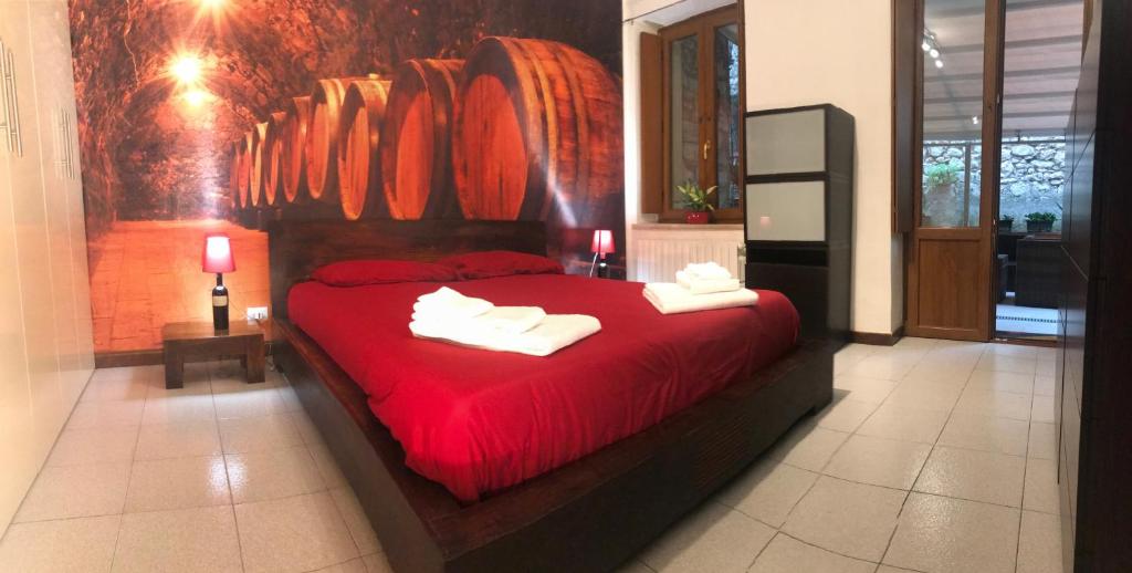 Un dormitorio con una cama roja con toallas. en Garden Wine Suite, en Verona