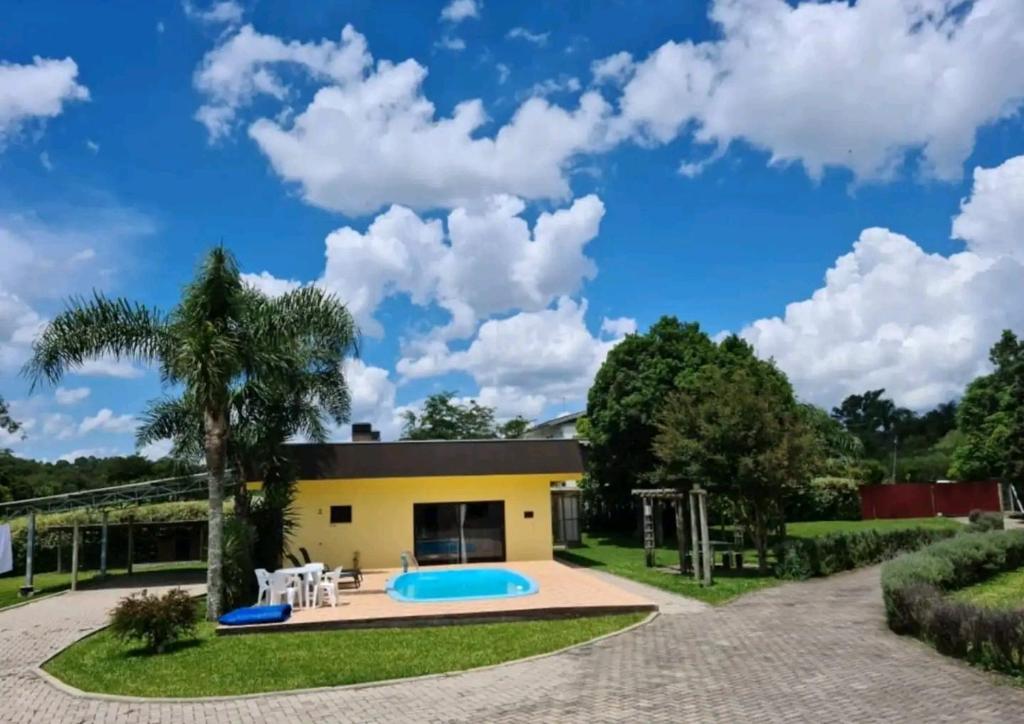 a house with a pool and a playground at Chácara Por do Sol in Farroupilha