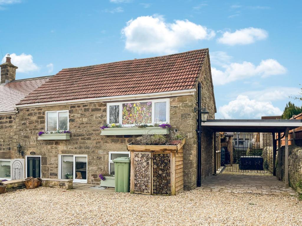 a brick house with a large window on it at Holly Cottage in Ashover