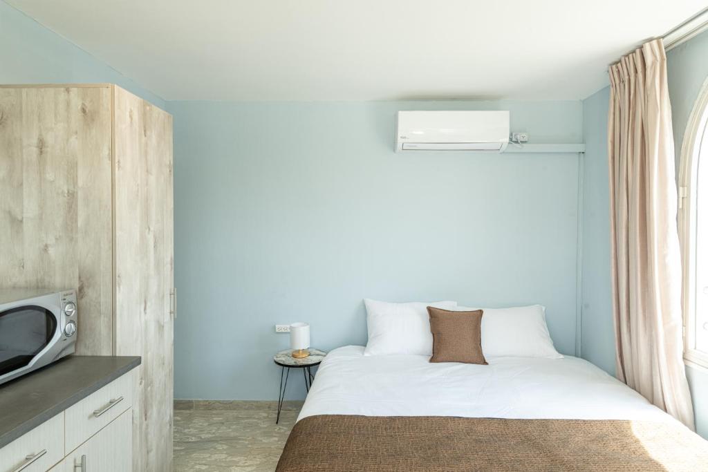 a small bedroom with a bed and a tv at Villa Li Eilat in Eilat