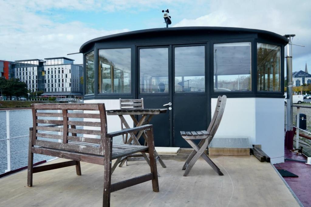 um deque com uma mesa e cadeiras num barco em Grande suite avec terrasse sur le fleuve em Nantes
