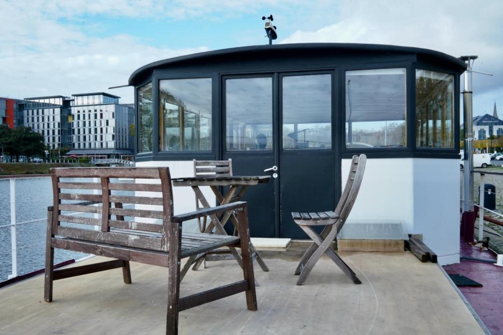 une terrasse avec une table et des chaises sur un bateau dans l'établissement Grande suite avec terrasse sur le fleuve, à Nantes