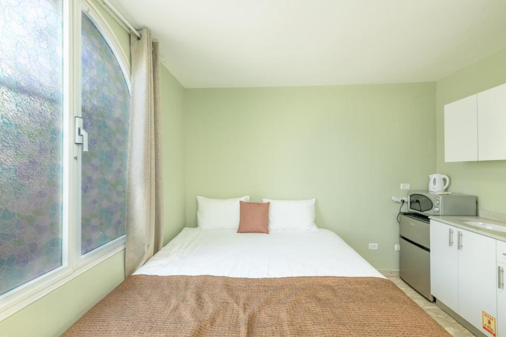 a small bedroom with a bed and a window at Villa Li Eilat in Eilat