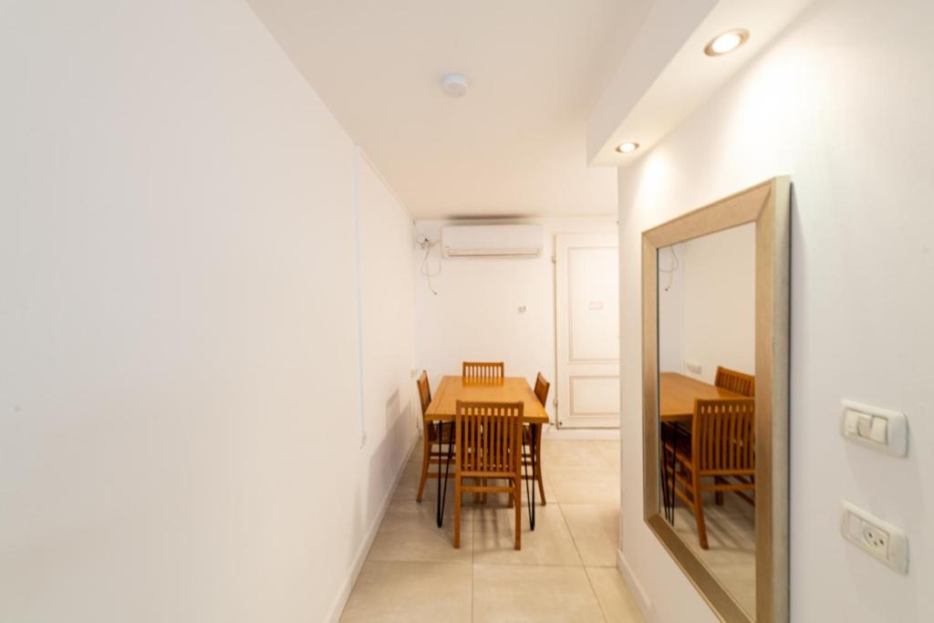 a dining room with a table and chairs and a mirror at Villa Li Eilat in Eilat