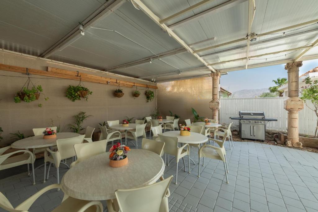 a patio with tables and chairs and a grill at Villa Li Eilat in Eilat