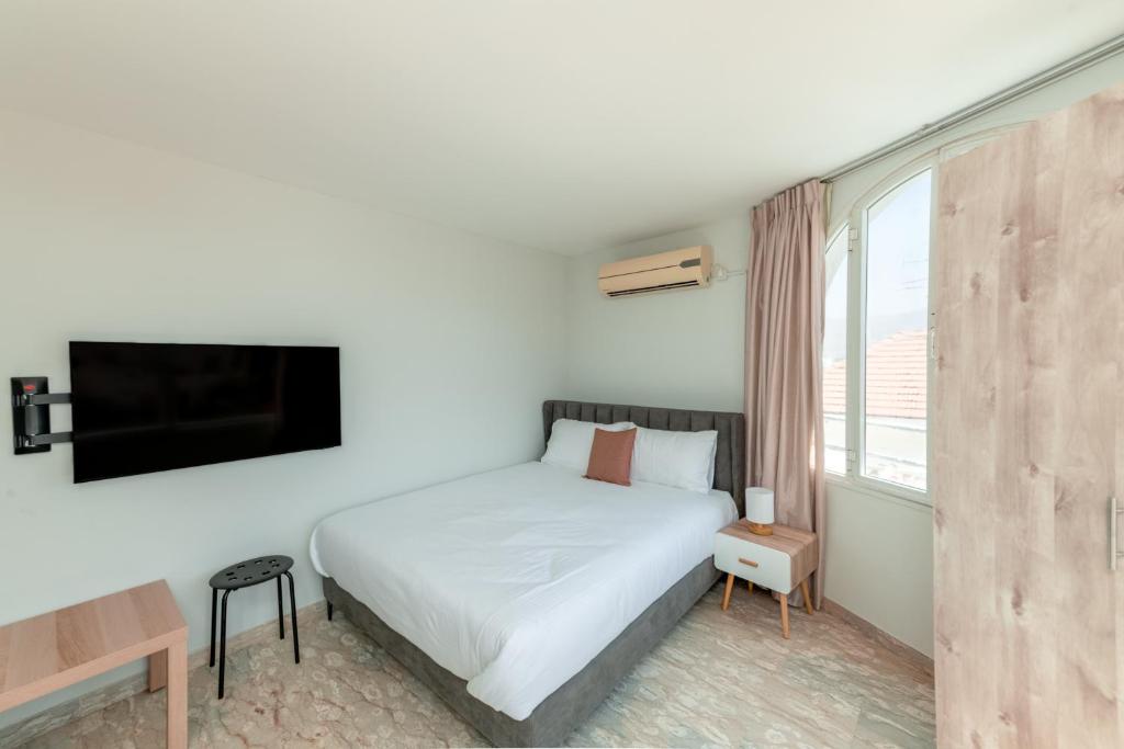 a bedroom with a white bed and a large window at Villa Li Eilat in Eilat